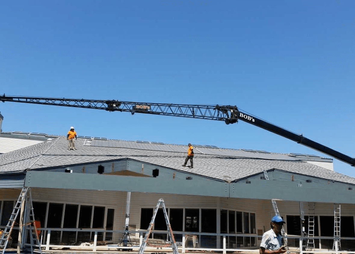 Workers installing roof shingles