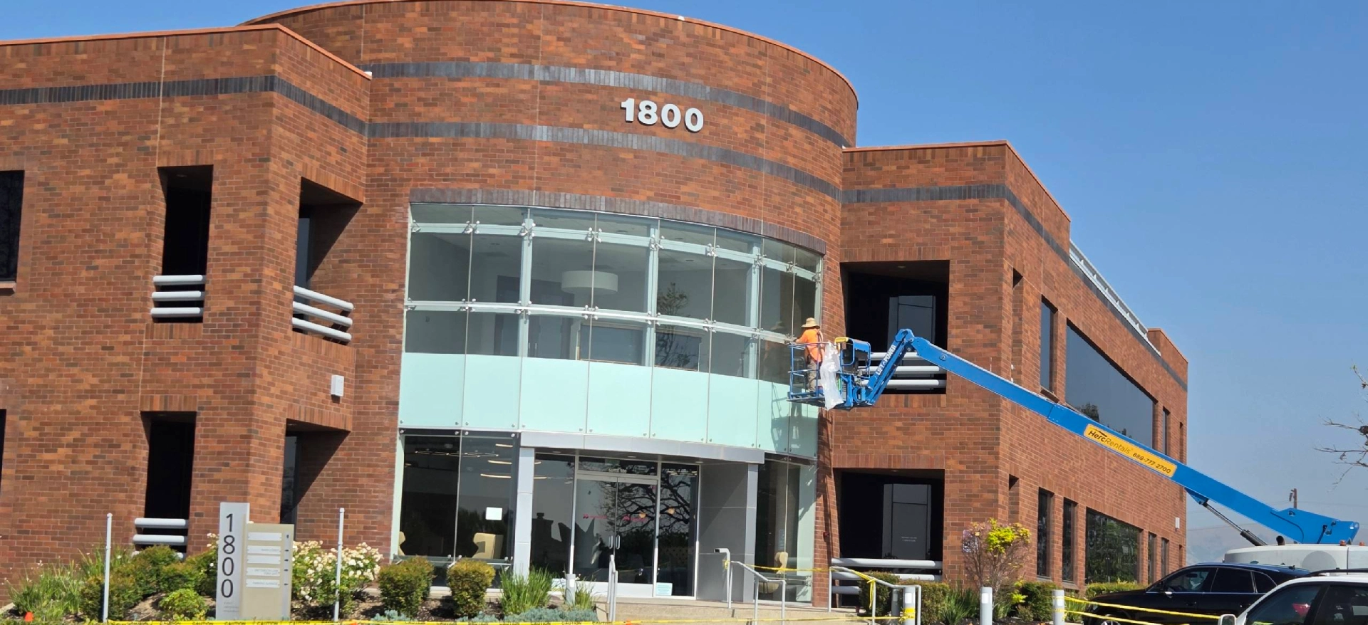 Worker on lift at brick office building