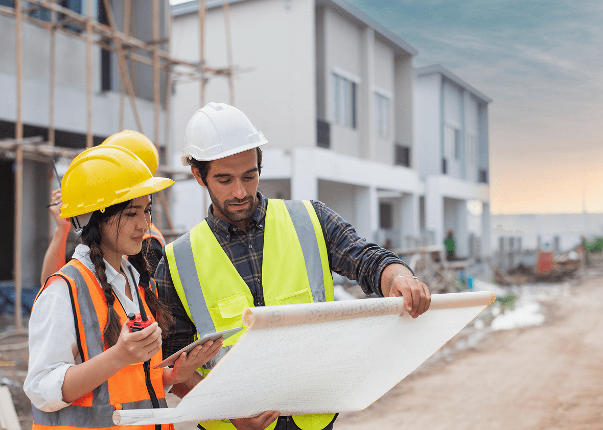 Engineers examining blueprints at construction site